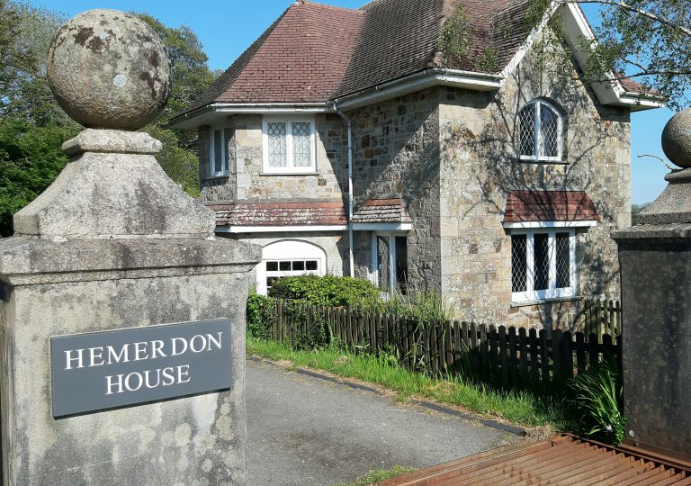 The entrance to Hemerdon House, the Lodge on the right, a sign on a granite pillar on the left saying Hemerdon House
